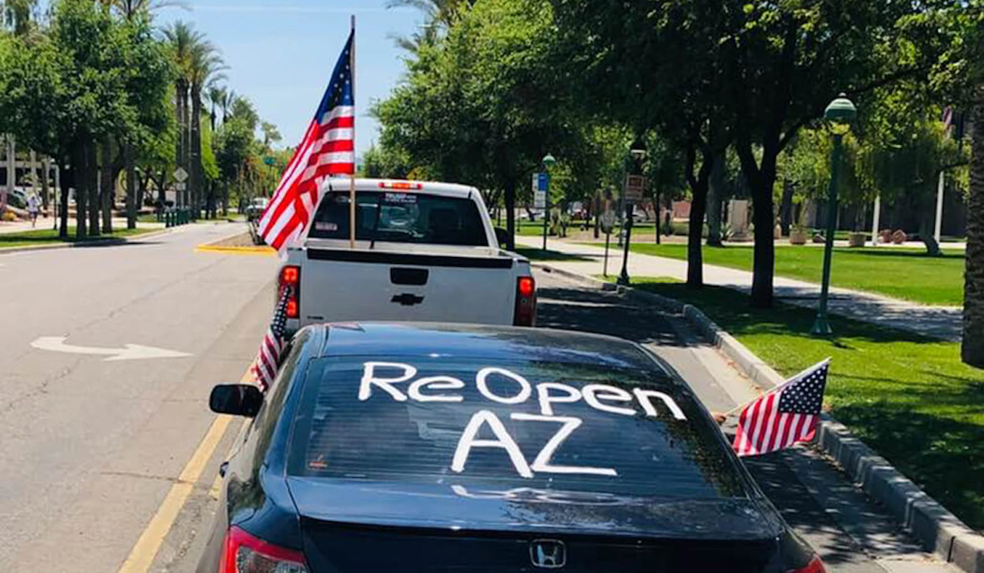 truck and car part of protest, car's back windshield reads "Reopen AZ"