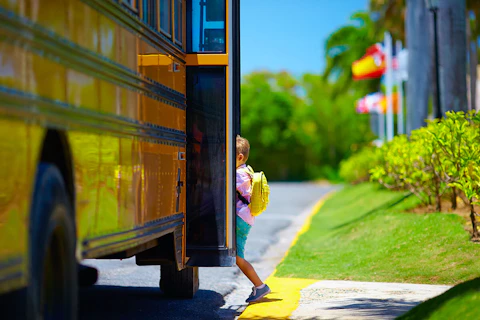 small boy boarding school bus