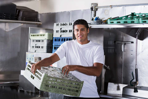 Hispanic man working as bus boy in restaurant kitchen. Photo courtesy kali9/E+/Getty Images