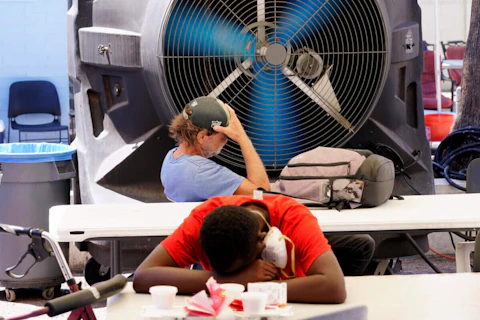 FILE - People try to keep cool at the Justa Center, a resource center catering to the older homeless population, as temperatures hit 110-degrees, July 19, 2022, in Phoenix. (AP Photo/Ross D. Franklin, File)