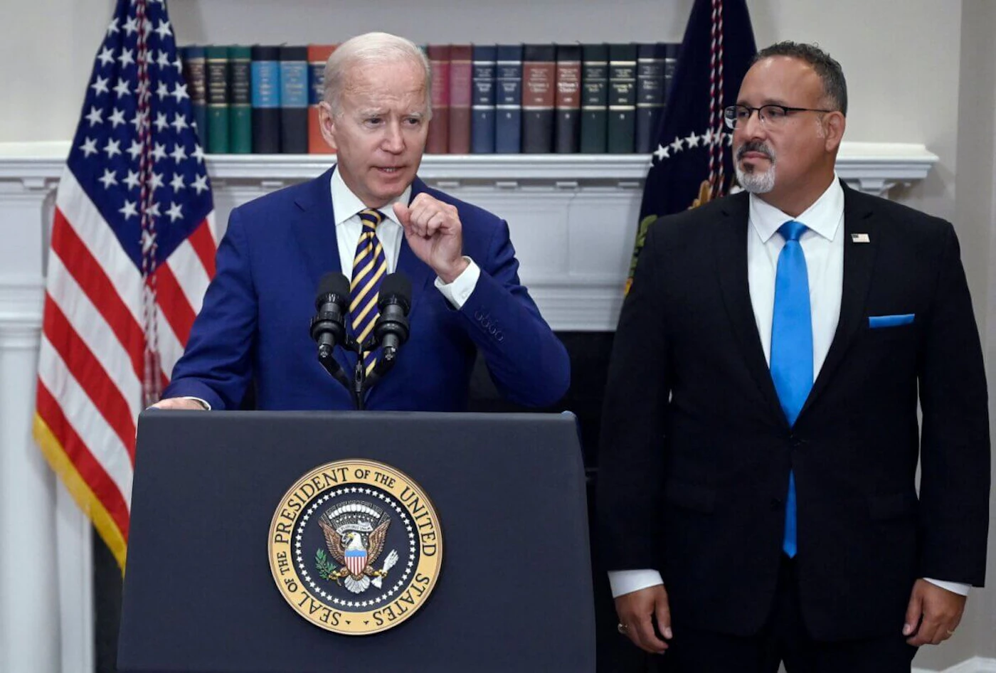 US President Joe Biden announces student loan relief with Education Secretary Miguel Cardona (R) on August 24, 2022 in the Roosevelt Room of the White House in Washington, DC. - Biden announced that most US university graduates still trying to pay off student loans will get $10,000 of relief to address a decades-old headache of massive educational debt across the country. (Photo by OLIVIER DOULIERY / AFP) (Photo by OLIVIER DOULIERY/AFP via Getty Images)