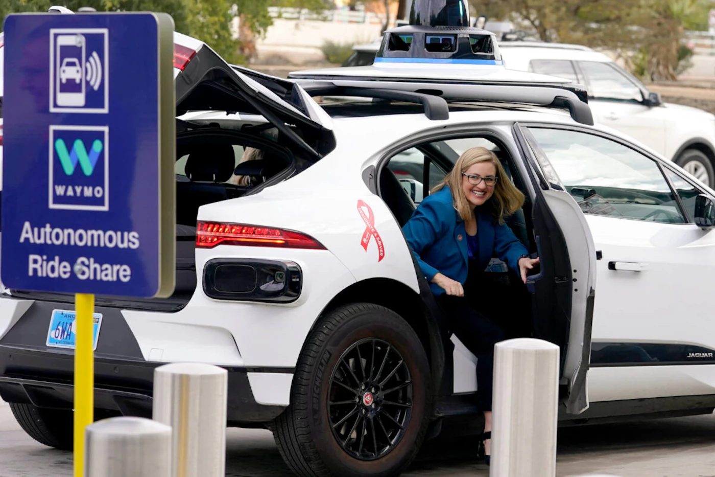 FILE - Phoenix Mayor Kate Gallego arrives in a Waymo self-driving vehicle on Dec. 16, 2022, at the Sky Harbor International Airport Sky Train facility in Phoenix. Self-driving car pioneer Waymo announced Thursday, May 4, 2023, that its robotaxis will be able to carry passengers through most of the Phoenix area for the first time. (AP Photo/Matt York, File)