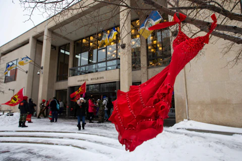 FILE - A red dress hangs on a tree in the courtyard at Winnipeg City Hall during a rally, Thursday, Dec. 15, 2022, in Winnipeg, Manitoba, to call on the city to cease dumping operations at Brady landfill and conduct a search for the remains of missing and murdered indigenous women believed to be buried there. Friday, May 5, 2023, marks Missing and Murdered Indigenous Peoples Awareness Day, a solemn day meant to draw more attention to the disproportionate number of Indigenous people who have vanished or have faced violence. (Daniel Crump/The Canadian Press via AP, File)