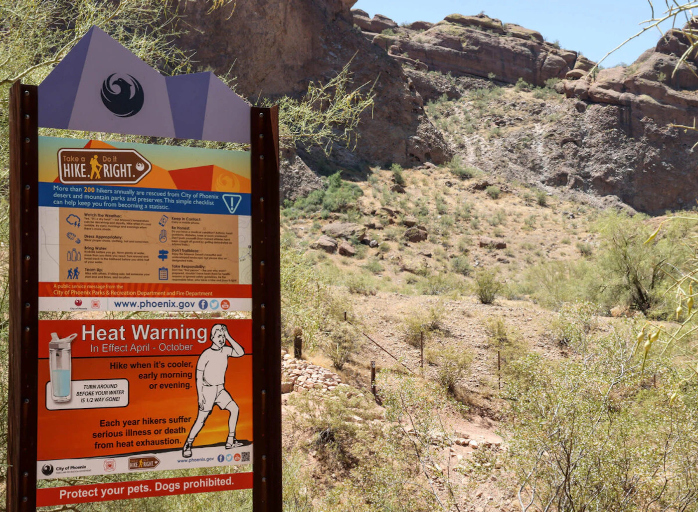 “Take a Hike, Do it Right” signs warn visitors of the dangers while hiking in hot conditions. The city limits hiking on some popular trails from 11 a.m. to 5 p.m. on days the National Weather Service issues an excessive heat warning. (Photo by Evelin Ruelas/Cronkite News)