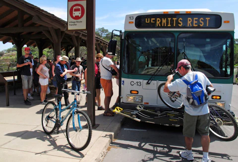 In this Aug. 19, 2015 file photo, a visitor loads his bike on a shuttle bus at Grand Canyon National Park in northern Arizona. (AP Photo/Felicia Fonseca, File)