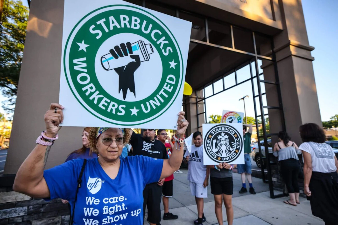 Great Neck, N.Y.: A woman holds up a sign as she joins other protestors in a rally against what they perceive to be union busting tactics, outside a Starbucks in Great Neck, New York,  demanding the reinstatement of a former employee on August 15, 2022. (Photo by Thomas A. Ferrara/Newsday RM via Getty Images)