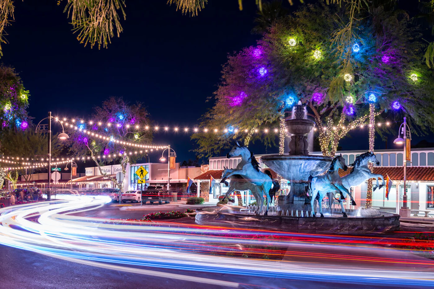 Scottsdale, AZ - February 9 2020: Traffic at night around Bob Parks' Bronze Horse Fountain in Old Town Scottsdale's 5th Avenue Shopping district. (Shutterstock Photo/kenelamb photographics)