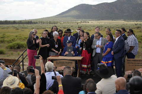 President Joe Biden holds up a proclamation designating the Baaj Nwaavjo I'Tah Kukveni National Monument at the Red Butte Airfield Tuesday, Aug. 8, 2023, in Tusayan, Ariz. (AP Photo/John Locher)