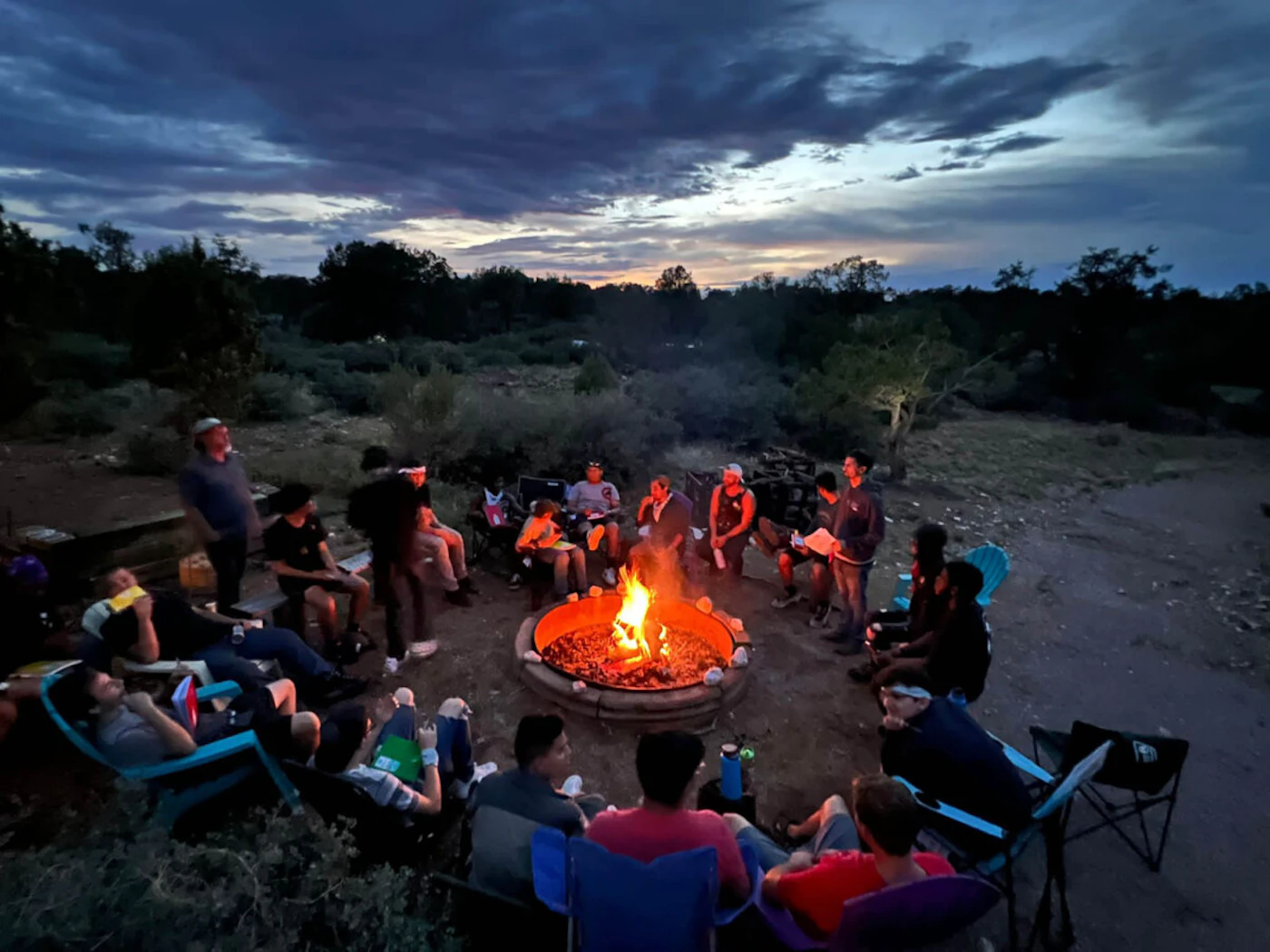 Young men and their mentors gather around a campfire at a Boys to Men camping weekend. (Photo courtesy of Boys to Men Tucson)