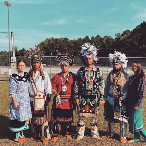 Six members of the Littleturtle family, who are Lumbee and Tuscarora, wear traditional regalia for a dance.