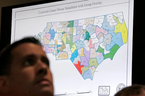 FILE - In this Monday, July 15, 2019 file photo, a state districts map is shown as a three-judge panel of the Wake County Superior Court presides over the trial of Common Cause, et al. v. Lewis, et al, in Raleigh, N.C.  North Carolina has often been cited as an example of political gerrymandering. Now court rulings against its legislative and congressional districts also could become an example for other states. (AP Photo/Gerry Broome, File)