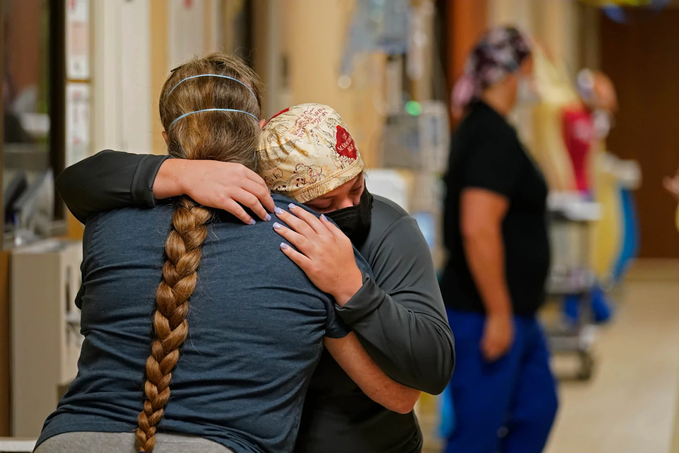 ICU nurse Melinda Hunt, facing, hugs the sister of a COVID-19 patient who she had been caring for after the patient died in 2021 in Shreveport, La. (AP Photo/Gerald Herbert, File)