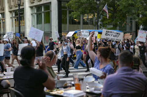 A protest against the Supreme Court's decision in the Dobbs v Jackson Women's Health case passes by a restaurant on June 24, 2022 in Raleigh, North Carolina.(Photo by Allison Joyce/Getty Images)