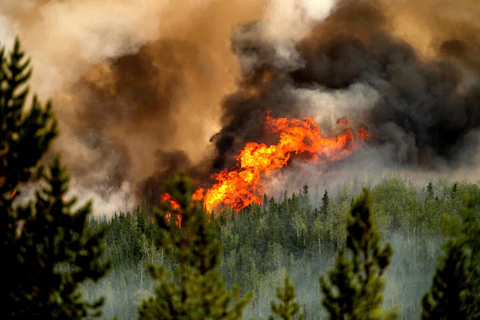 Flames from the Donnie Creek wildfire burn along a ridge top north of Fort St. John, British Columbia, Canada, Sunday, July 2, 2023. Continuing wildfires in Canada have impacted air quality in North Carolina. (AP Photo/Noah Berger)