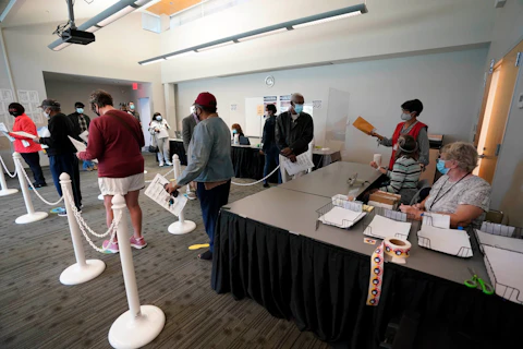 Early voters line up to cast their ballots inside the South Regional Library polling location in Durham, N.C., in October, 2020. (AP Photo/Gerry Broome, File)