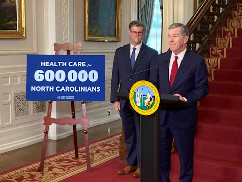 North Carolina Gov. Roy Cooper, right, speaks while state Health and Human Services Secretary Kody Kinsley listens at an Executive Mansion news conference in Raleigh, N.C., on Monday, Sept. 25, 2023. Cooper and Kinsley announced that North Carolina would launch Medicaid expansion coverage on Dec. 1. Expansion will be able to start because Cooper said he'll let a state budget bill sent by the General Assembly last week to his desk become law without his signature. (AP Photo/Gary D. Robertson)