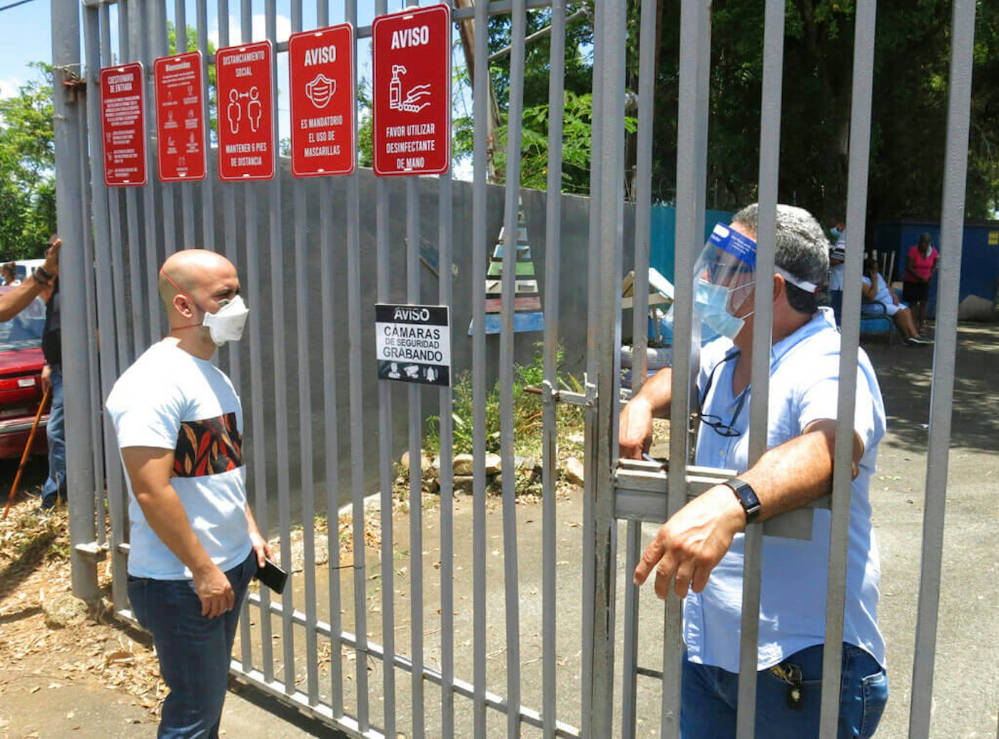 An electoral official, right, tells a voter that the ballots haven't arrived at a voting center in Carolina, Puerto Rico, Sunday, Aug. 9, 2020. Puerto Rico's primaries were marred by a lack of ballots in a majority of centers across the island. Puerto-Rico-Primaries-failure