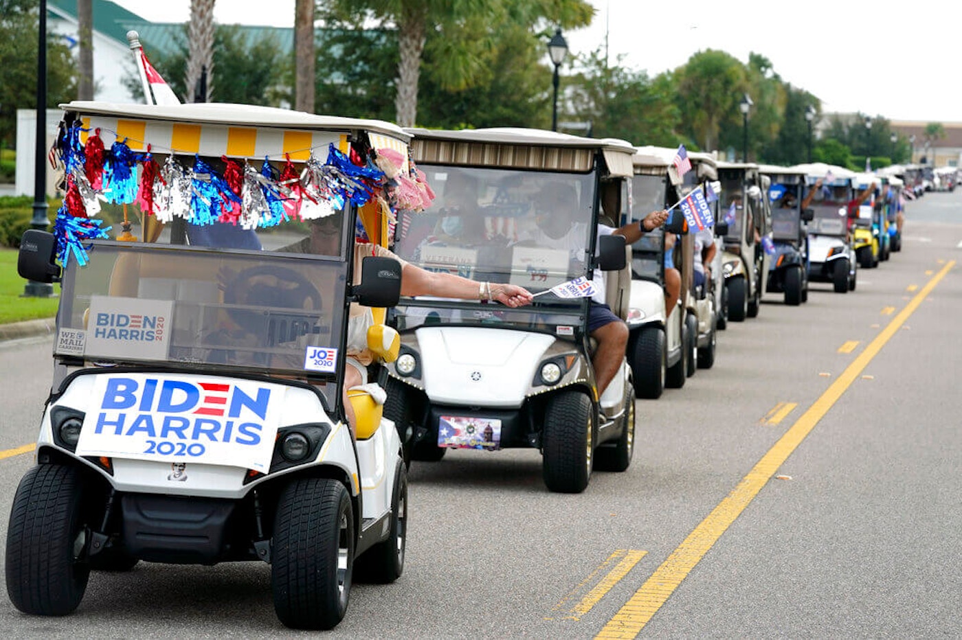 A parade of over 300 golf carts supporting Democratic presidential candidate Joe Biden caravanned to the Sumter County Elections office to cast their ballots during early voting Wednesday, Oct. 7, 2020, in The Villages, Florida. The Villages, a retirement community, is predominantly Republican but there are growing numbers of Democrats moving there. florida-senior-citizens-biden