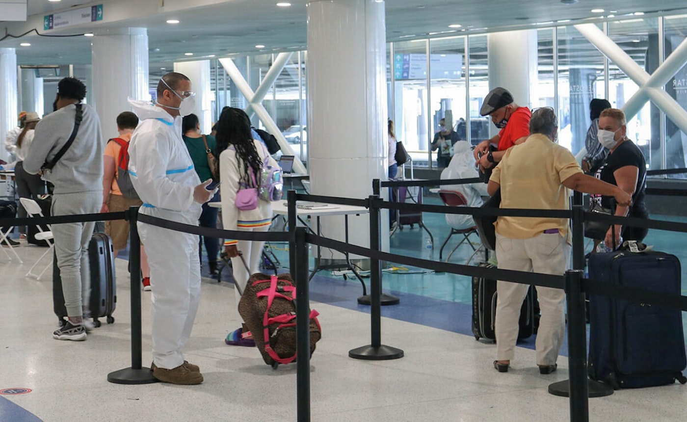 Efectivos de la Guardia Nacional de Puerto Rico les toman la temperatura a los pasajeros al salir del terminal de equipajes. Viajar-Puerto-Rico