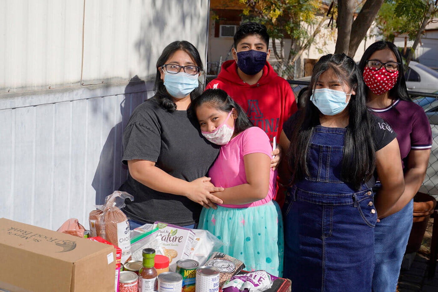 From left, Abigail Leocadio, stands with her children, Areli, 9, Eliel, 12, Zeret, 10, and Samai, 15, after a delivery from the Emmaus House food pantry Saturday, Nov. 14, 2020, in Phoenix, Arizona. snap-covid-relief