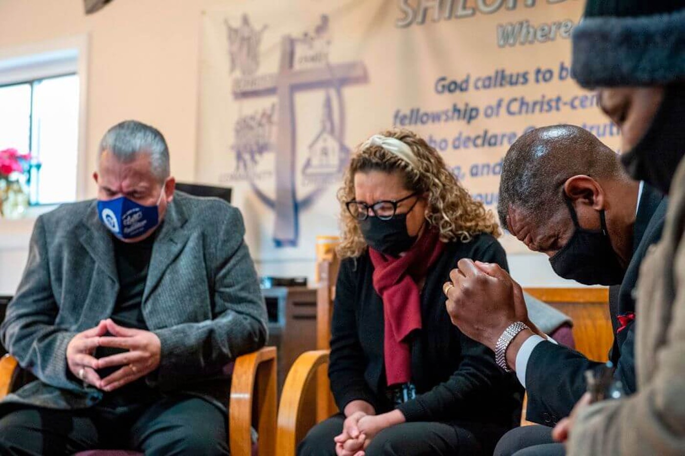 From left: Religious leaders Bishop Héctor Hernández, Pastor Yolanda Hernández, and Pastor Carl McCluster pray with Earlee Green at Shiloh Baptist Church before heading to receive their vaccinations against COVID-19 in Bridgeport, Conn. on Feb. 26, 2021. latino-covid-vaccine