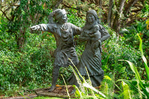 Statue of Miccosukee leader Sam Jones (Ar-pi-uck-i or Abiaka) leading women and children to safety at Pine Island Ridge Natural Area. Image via Shutterstock.
