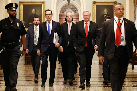 Treasury Secretary Steven Mnuchin, left, accompanied by White House Legislative Affairs Director Eric Ueland and acting White House chief of staff Mark Meadows, walks to the offices of Senate Majority Leader Mitch McConnell of Ky. on Capitol Hill in Washington, Tuesday, March 24, 2020. (AP Photo/Patrick Semansky)