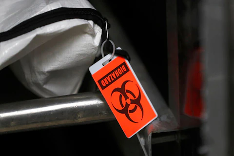 An orange biohazard tag hangs from a body bag in an isolated refrigerated unit set aside for bodies infected with coronavirus at the Cook County morgue in Chicago. (AP Photo/Charles Rex Arbogast)