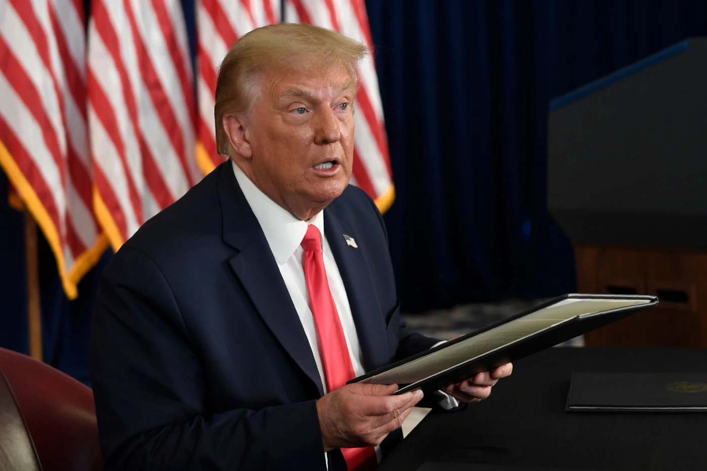 President Donald Trump prepares to sign four executive orders during a news conference at the Trump National Golf Club in Bedminster, N.J., in a Saturday, Aug. 8, 2020 file photo. (AP Photo/Susan Walsh, File)