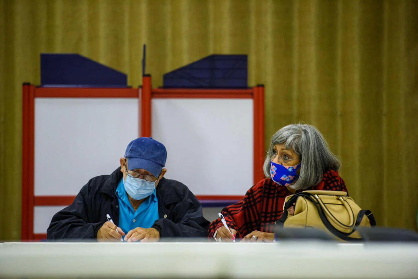 A couple fills out ballots together at the O.P. Owens Building on November 3, 2020  in Lumberton, North Carolina.  After a record-breaking turnout during the 2020 election, Democrats and Republicans are at odds over Democrats plans to expand voting access through the 'For the People Act.' (Photo by Melissa Sue Gerrits/Getty Images)
