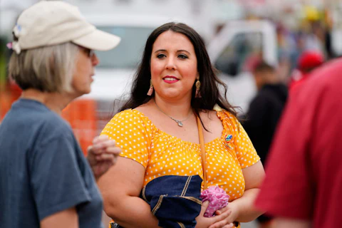 Alicia Duque, a 35-year-old mother of three and volunteer organizer for the progressive group, Action Together listens to Claudia Glennan at the Edwardsville Pierogi Festival in Edwardsville, Pa., Friday, June 11, 2021. (AP Photo/Matt Rourke)