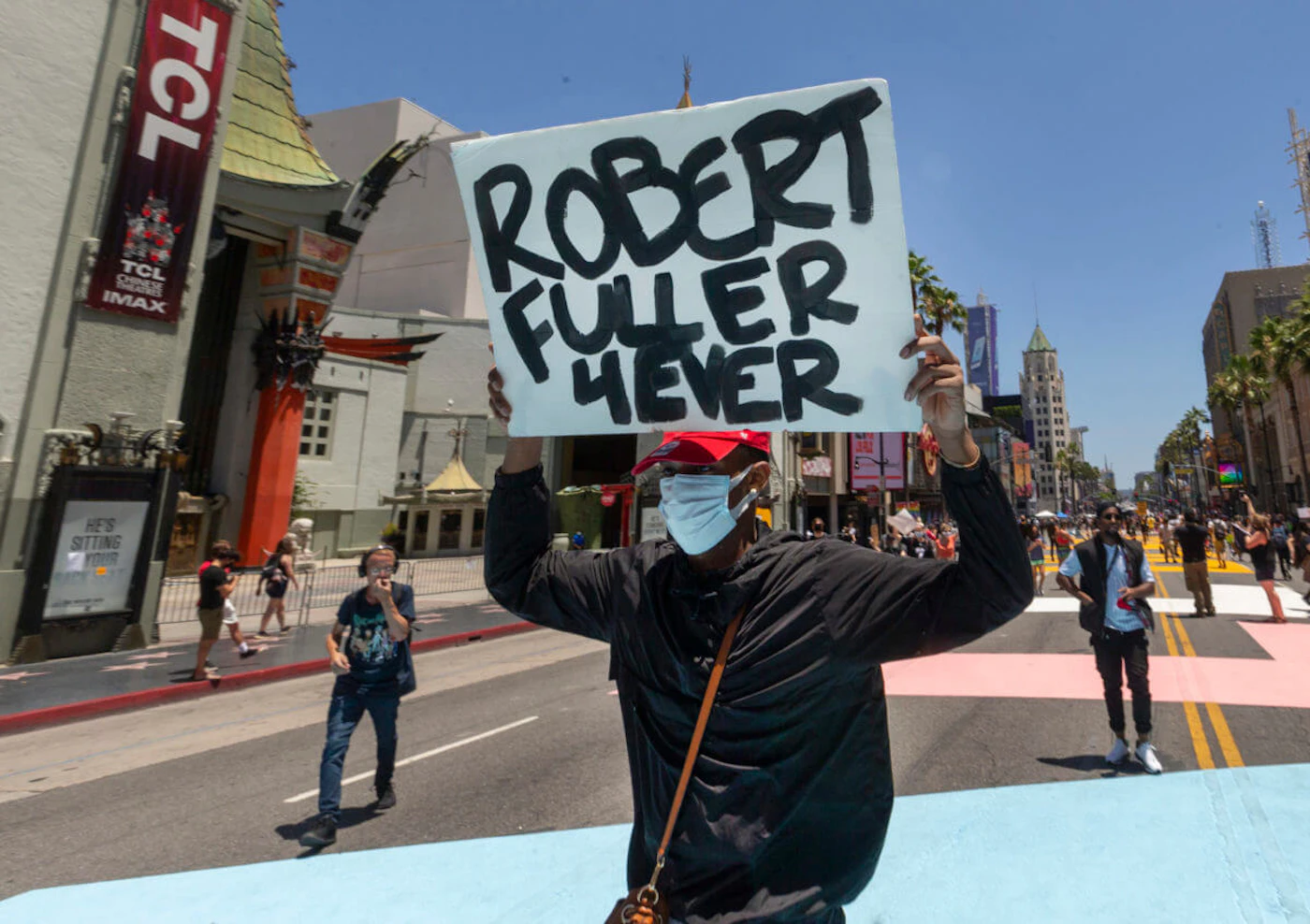 A demonstrator carries a sign reading: "Robert Fuller 4Ever" during an All Black Lives Matter march organized by black members of the LGBTQ community, in the Hollywood section of Los Angeles on Sunday, June 14, 2020. (AP Photo/Damian Dovarganes)