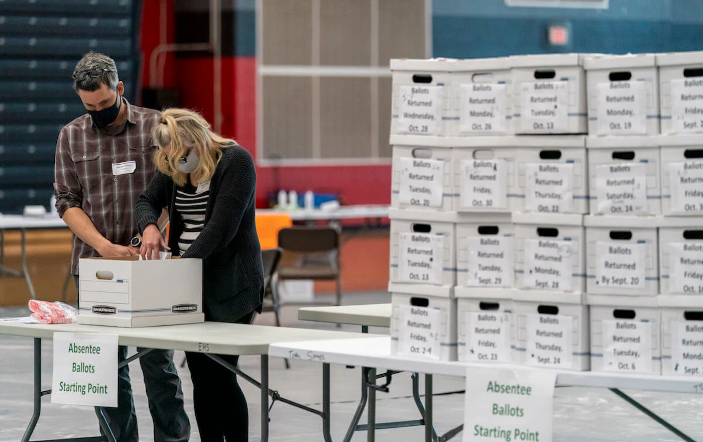 Poll workers Angela and Zach Achten check-in a box of absentee ballots in the gym at Sun Prairie High School on Election Day. The entire gym was dedicated to counting the absentee ballots. The state's top election official again defended the integrity of the ballot-counting and entire election process in Wisconsin Thursday. (Photo by Andy Manis/Getty Images)