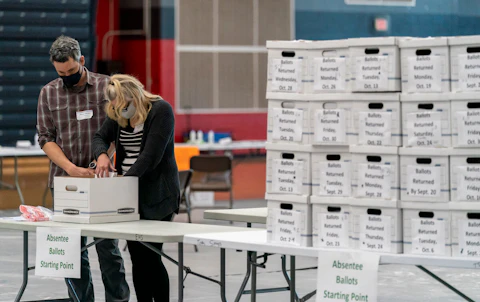 Poll workers Angela and Zach Achten check-in a box of absentee ballots in the gym at Sun Prairie High School on Election Day. The entire gym was dedicated to counting the absentee ballots. The state's top election official again defended the integrity of the ballot-counting and entire election process in Wisconsin Thursday. (Photo by Andy Manis/Getty Images)