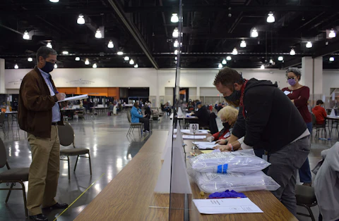 At left, Bill Bridge, a Trump-supporting recount observer, watches election officials work last November at the Wisconsin Center in Milwaukee. The 2020 presidential election has repeatedly been shown to have been secure and accurate despite numerous recounts, challenges, and ongoing baseless claims.(Photo by Jonathon Sadowski)