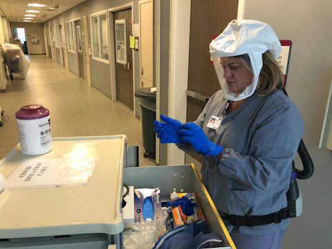 Nurse supervisor DeAnna North dresses in protective clothing before treating patients at Marshfield Medical Center-Eau Claire’s Intensive Care Unit. Hospitals around Wisconsin are reaching capacity. An experimental drug could help that scenario.(Photo courtesy of Marshfield Clinic Health System)