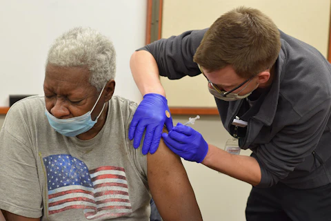 Ted Crutcher, 70, of Milwaukee, gets a dose of Pfizer's COVID-19 vaccine Feb. 4 from Jordan Bretzmann, a nurse at Progressive Community Health Centers. (Photo by Jonathon Sadowski)