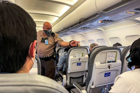 A passenger is removed from a United Airlines flight in Miami, on March 17, 2021. The Federal Aviation Administration logged a record 5,981 reports of unruly passenger behavior last year—more than 70% involving passengers refusing to comply with well-known and widely advertised face mask safeguards. (Photo by CHANDAN KHANNA / AFP) (Photo by CHANDAN KHANNA/AFP via Getty Images)