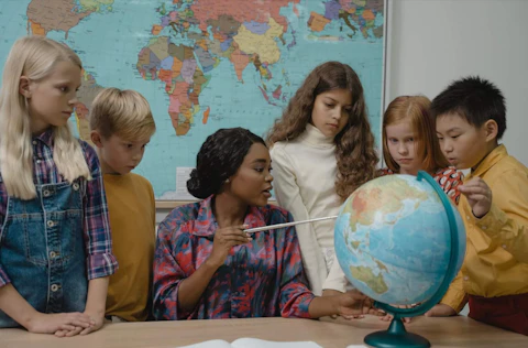 Students gathering around a teacher (https://www.pexels.com/photo/teacher-teaching-students-about-geography-using-a-globe-5428267/)