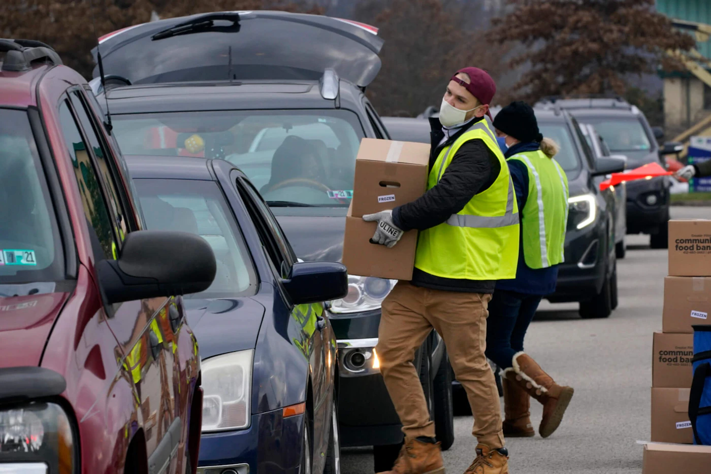 Volunteers load boxes of food into a car during a Greater Pittsburgh Community Food bank drive-up food distribution in Duquesne, Allegheny County, on Nov. 23, 2020. (AP Photo/Gene J. Puskar)