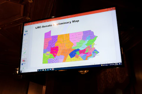 A proposed Pennsylvania Senate district map is displayed during a meeting of the Pennsylvania Legislative Reapportionment Commission at the Capitol in Harrisburg, Pa., Thursday, Dec. 16, 2021. The commission voted Thursday in favor of new preliminary district maps over sharp objections from the House's Republican leader about how his chamber's district lines would change. (AP Photo/Matt Rourke)