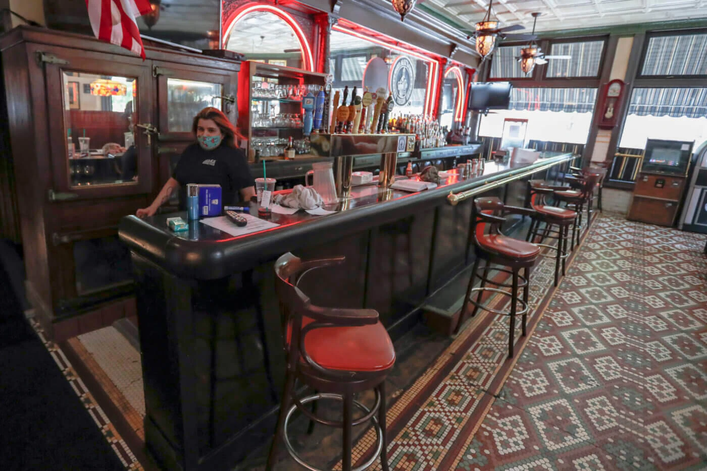 Bartender Sara Kennely, walks behind the bar as preparations, like spacing out the barstools, are underway, Thursday, June 4, 2020, at Max's Allegheny Tavern on Pittsburgh's North Side for patrons to dine inside is permitted when most of southwest Pennsylvania loosens COVID-19 restrictions allowing eat-in dining on Friday. (AP Photo/Keith Srakocic)