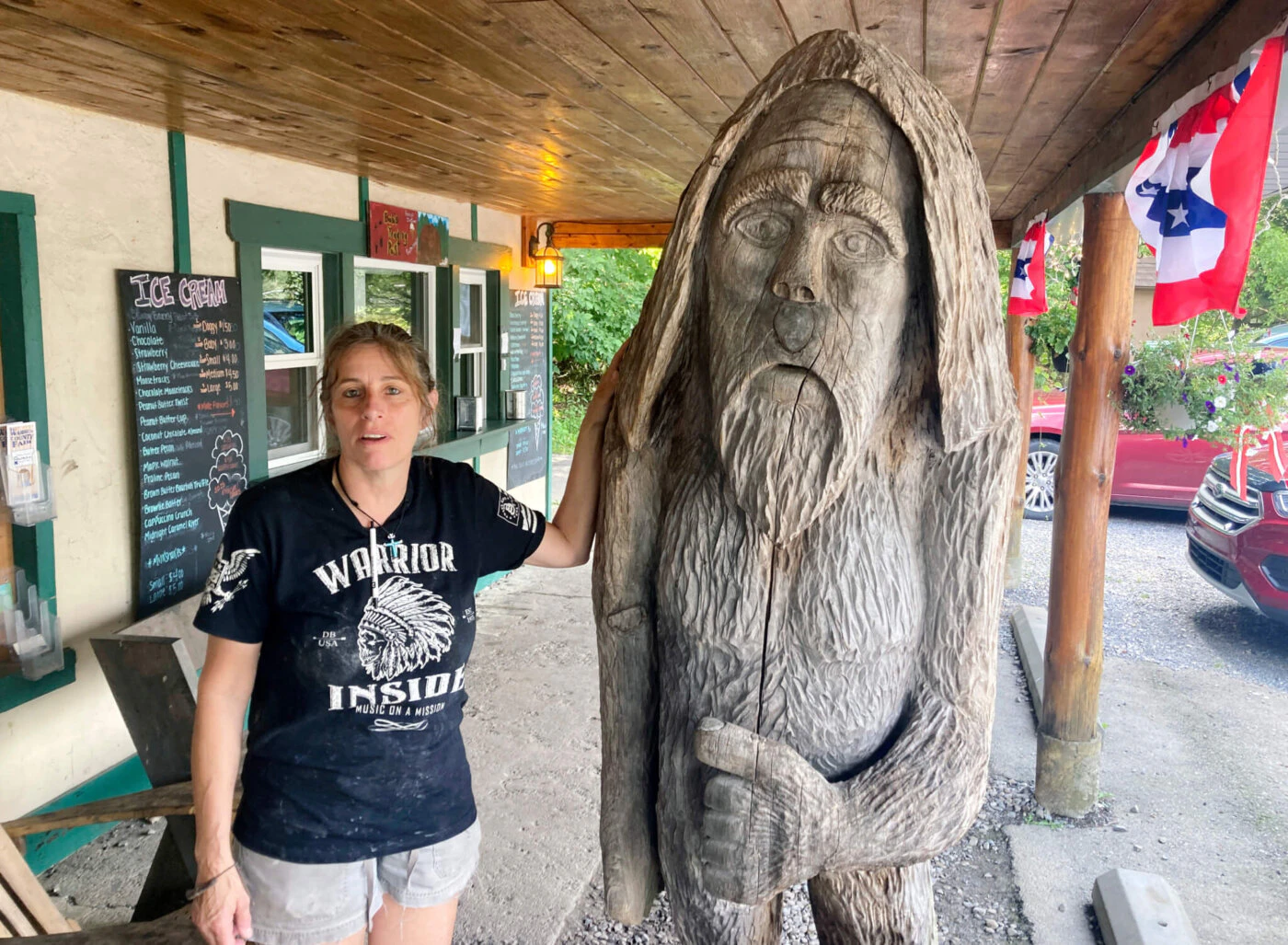 FILE - Pauline Bauer leans against a wooden statue outside Bob's Trading Post, her restaurant in Hamilton, Pa., July 21, 2021. Bauer, who screamed death threats directed at then-House Speaker Nancy Pelosi while storming the U.S. Capitol on Jan. 6, 2021, was sentenced on Tuesday to two years and three months in prison. (AP Photo/Michael Kunzelman)