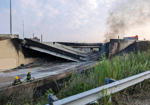 This image provided by the Office of Emergency Management shows firefighters standing near the collapsed part of I-95 in Philadelphia, Sunday, June 11, 2023. The elevated section of Interstate 95 has collapsed early Sunday after a vehicle caught fire, closing the main north-south highway on the East Coast and threatening to upend travel in parts of the densely populated Northeast. (Office of Emergency Management via AP)