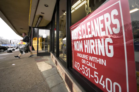 FILE - A "Now Hiring" sign hangs in the windows of Ruby's Cleaners in Mount Lebanon, Pa., on Jan. 23, 2023. (AP Photo/Gene J. Puskar, File)