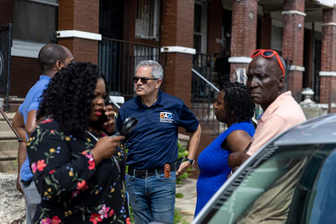 District Attorney Larry Krasner and other officials are walk through the neighborhood after last night's mass shooting in Philadelphia, on Tuesday, July 4, 2023. Police say a gunman in a bulletproof vest has opened fire on the streets of Philadelphia Monday night, killing several people and wounding two boys before he surrendered to responding officers. (Tyger Williams/The Philadelphia Inquirer via AP)