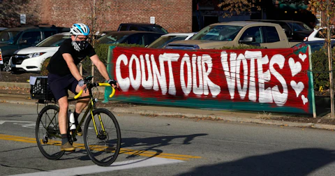 In this Nov. 10, 2020, file photo, a bicyclist passes a "Count Our Votes" sign near the Allegheny County Election Division Warehouse on Pittsburgh's Northside, where votes were continue to be counted from the Nov. 3, 2020 general election. A Republican proposal made public on Thursday, June 10, 2021, would revamp Pennsylvania election law to affect deadlines, early voting and mail-in ballots and require ID for all in-person voters. (AP Photo/Gene J. Puskar, File)