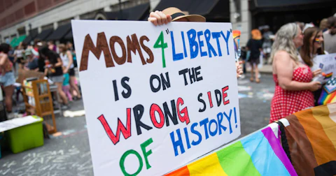 A protester holds a placard during a protest held by Philly Children's Movement against Moms For Liberty in Center City Philadelphia. Philly Children's Movement supporters and LGBTQ+ supporters gather to protest against the Mom's For Liberty, a group formed in 2021 to fight against COVID-19 Mandates. The Mom's For Liberty held their annual summit in Philadelphia. Mom's For Liberty is designated by the Southern Poverty Law Center as a hate group and has been a vocal voice in anti-LGBT rhetoric and the push in banning certain books from schools and libraries. (Photo by Matthew Hatcher via Getty Images)