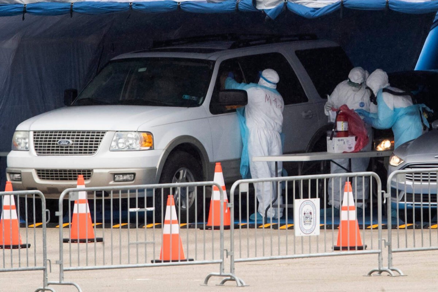 Medical workers perform a coronavirus test on driver at the Temple University Ambler campus in Ambler, Pa., Wednesday, March 25, 2020. (AP Photo/Matt Rourke)
