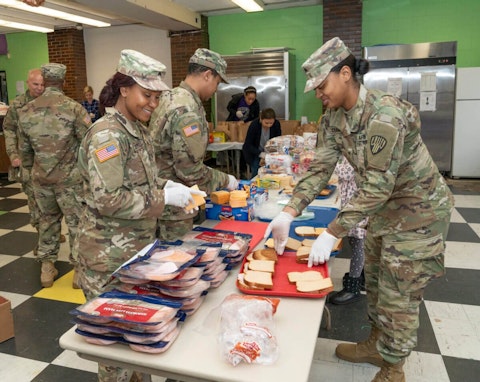 Members of National Guard & volunteers prepare bags of food to residents near a one-mile radius containment area set up to halt spread of COVID-19 in New York. Image via Shutterstock